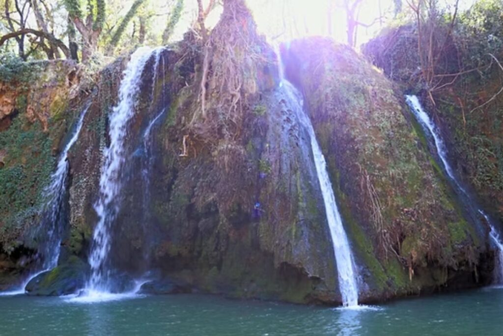 Bassin naturel au pied de la cascade du Grand Baou entouré de rochers et de végétation méditerranéenne