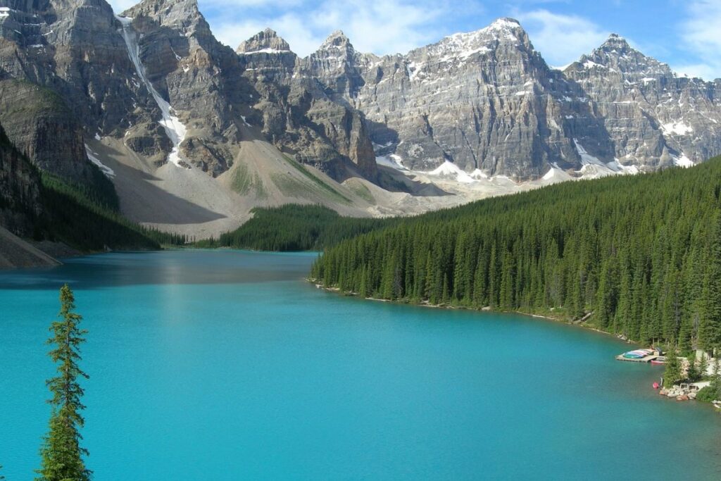 Lac turquoise entouré de sommets enneigés et de conifères dans le parc national de Banff, Rocheuses canadiennes