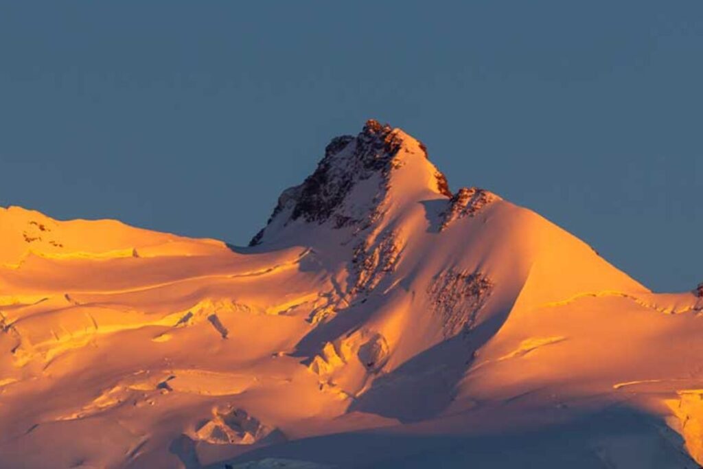Cordée d’alpinistes progressant sur une arête de neige dans le massif du Mont Rose, à la frontière italo-suisse