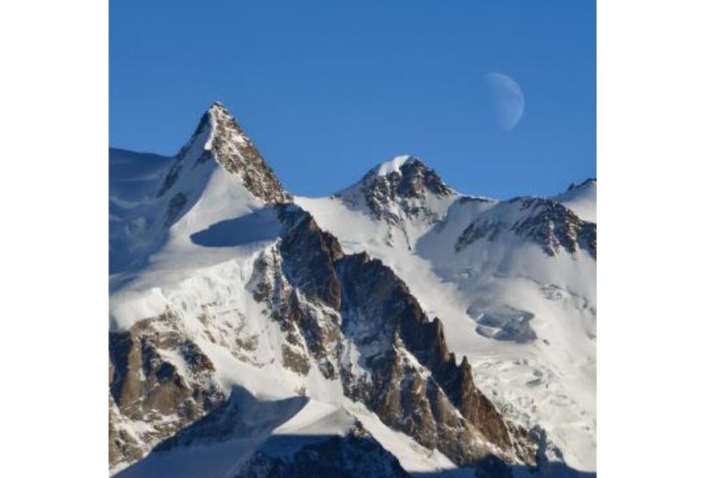 Alpinistes encordés en crampons sur une pente glaciaire raide du Mont Rose, sommets de plus de 4 000 mètres en arrière-plan