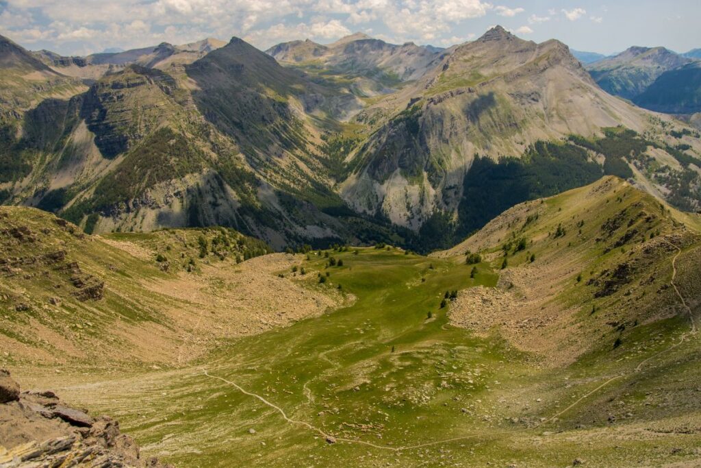 Lac de montagne entouré de mélèzes et de sommets encore enneigés au printemps dans le Mercantour